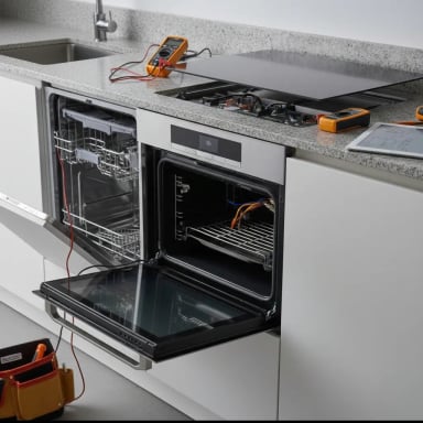 Modern kitchen appliances with open dishwasher and oven